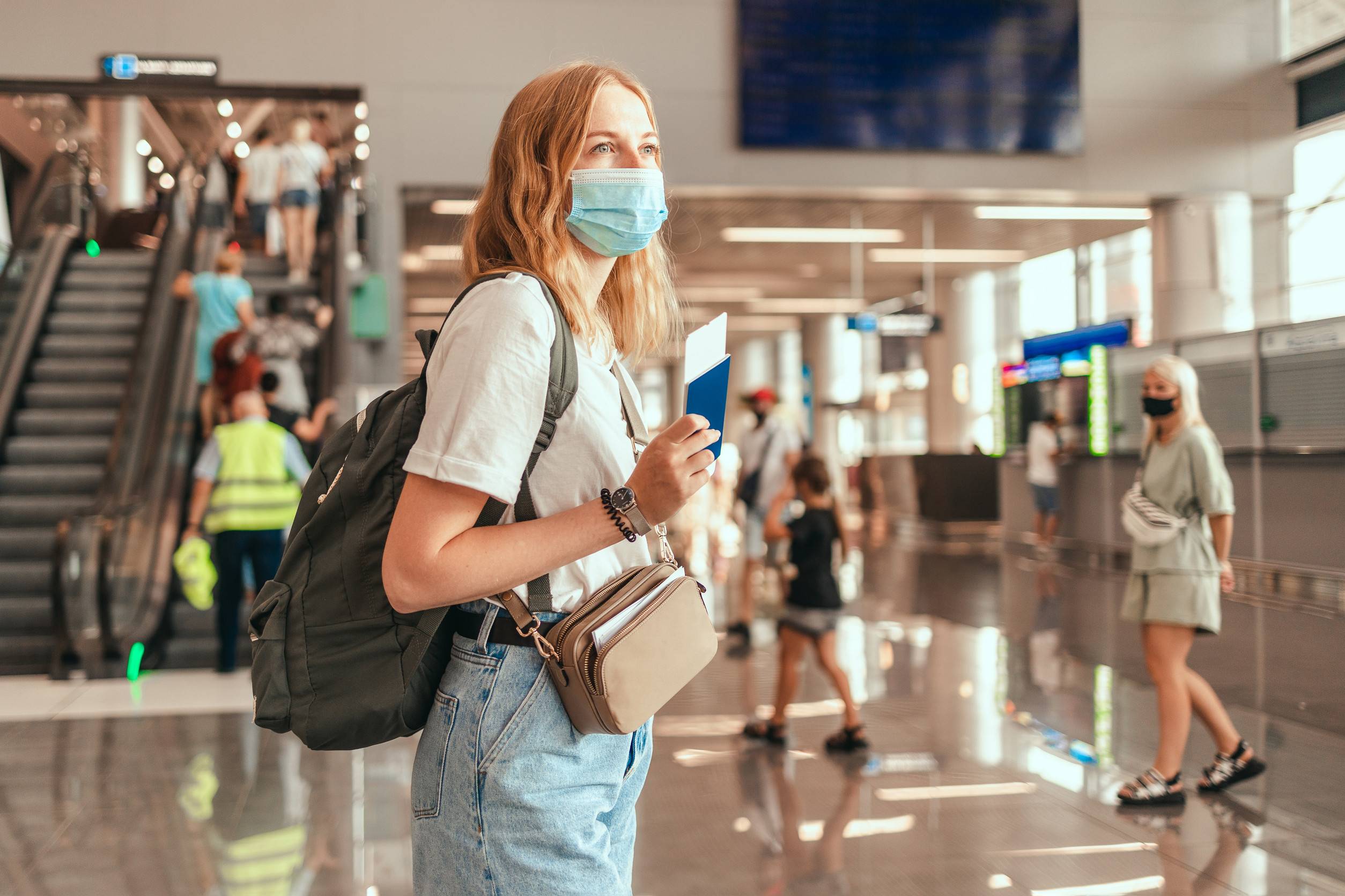 Blonde Hair Female Tourist Hand Holding Passport With Suitcase Luggage